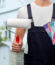 repair, construction and building - close up of painter or builder with paint roller and color charts over living house on background